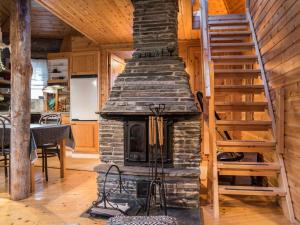 a stone fireplace in a living room with a staircase at Holiday Home Ylläsparit as- 2 by Interhome in Ylläsjärvi