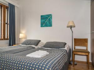 a bedroom with two beds and a lamp and a chair at Holiday Home Ylläs chalets a307 by Interhome in Ylläs
