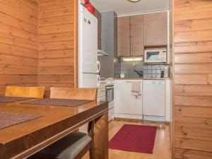 uma cozinha com um frigorífico branco e armários de madeira em Holiday Home Ylläs chalet a402 by Interhome em Ylläs