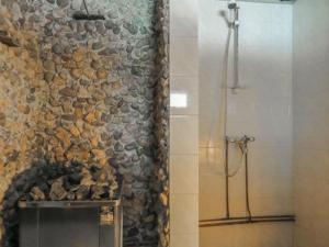 a bathroom with a stone wall and a shower at Holiday Home Kulpakko 1 by Interhome in Tiainen