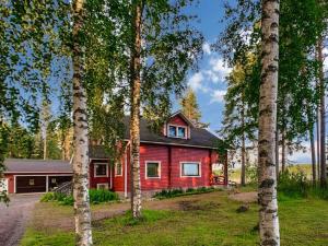 una casa rossa in mezzo ad alcuni alberi di Holiday Home Kallioniemi by Interhome a Toiviaiskylä