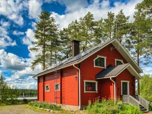 una casa rossa con un camino sopra di Holiday Home Kallioniemi by Interhome a Toiviaiskylä