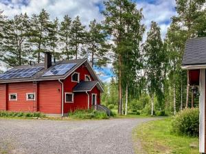 una casa rossa con pannelli solari sul tetto di Holiday Home Kallioniemi by Interhome a Toiviaiskylä