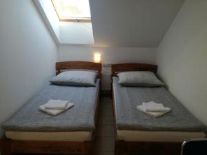 two beds in a small room with towels on them at U Justyny in Chróścice