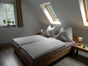 a bedroom with a bed and two windows at Ferienhaus Buschmuehle - Stolpen in Stolpen