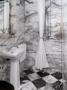 Baño blanco con lavabo y cortina de ducha en House of Gods Royal Mile en Edimburgo