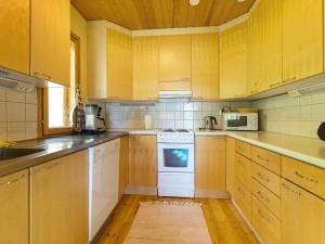 KalmariにあるHoliday Home Sammallehto by Interhomeのキッチン(白い家電製品、木製キャビネット付)