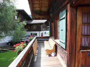 eine hölzerne Veranda mit einer Bank an einem Haus in der Unterkunft Apartment Lena- Chalet by Interhome in Gstaad