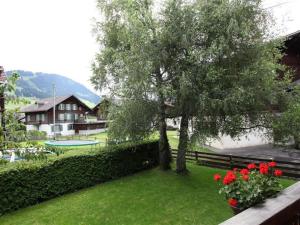 a view of a yard with a tree and a pool at Apartment Lena- Chalet by Interhome in Gstaad