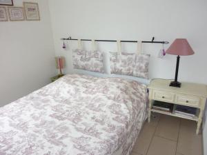ein Schlafzimmer mit einem Bett und einem Tisch mit einer Lampe in der Unterkunft Apartment Blumenweg 10 by Interhome in Engelberg