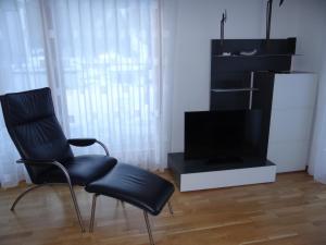 uma sala de estar com uma cadeira e uma televisão em Apartment Dorfstrasse 7-42 by Interhome em Engelberg