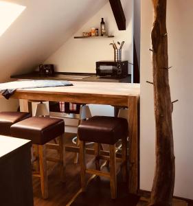 cocina con mesa de madera y taburetes en Moderne Wohnung im Grünen, en Werneuchen