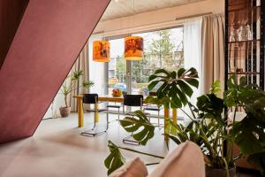 un soggiorno con tavolo, sedie e piante di New beautiful design studio in Amsterdam West ad Amsterdam