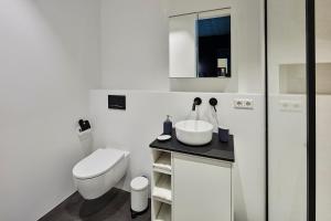 a white bathroom with a toilet and a sink at New beautiful design studio in Amsterdam West in Amsterdam