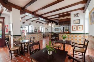 a restaurant with tables and chairs and a bar at Hotel El Convento in Arcos de la Frontera
