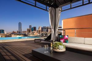 a rooftop patio with a view of the city at Canvas Hotel Dallas in Dallas