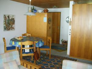 eine Küche und ein Esszimmer mit einem Tisch und Stühlen in der Unterkunft Apartment Balmehus # 3 by Interhome in Lenk im Simmental