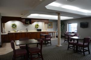 a waiting room with tables and chairs and a kitchen at Gateway Inn in Clarksville
