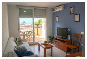 a living room with a couch and a television at Apartamentos Inma Mayor en primera línea de playa, con Parking y Piscina in Los Caños de Meca
