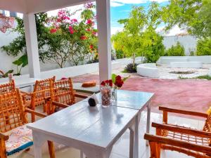 南威的住宿－Papaya Guest House Nungwi，庭院里的白色桌椅
