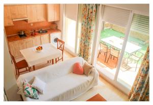 a living room with a couch and a kitchen with a table at Apartamentos Inma Mayor en primera línea de playa, con Parking y Piscina in Los Caños de Meca
