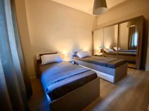 マントヴァにあるResidenza Bonomi 23のベッド2台と鏡が備わるホテルルームです。