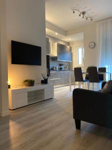 a living room with a couch and a tv on a wall at Residenza Bonomi 23 in Mantova