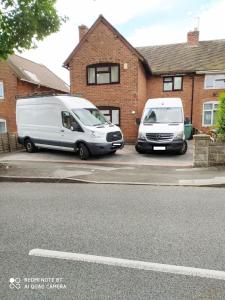 two white vans parked in front of a house at Manor Team Hse, M6 J10, Free Secure Onsite Parking, 8 beds in Walsall