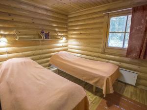 アカスロンポロにあるHoliday Home Ylläksen tunturihonkamaja a 1 by Interhomeのログキャビン内のベッド2台が備わる部屋です。