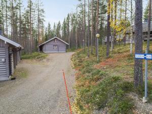 eine Feldstraße, die zu einem kleinen Gebäude im Wald führt in der Unterkunft Holiday Home Ylläksen tunturihonkamaja a 1 by Interhome in Äkäslompolo