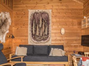 - un salon avec un canapé bleu dans un mur en bois dans l'établissement Holiday Home Lähikaltio 316 by Interhome, à Äkäslompolo