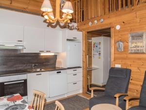 アカスロンポロにあるHoliday Home Lähikaltio 316 by Interhomeの白いキャビネット、テーブルと椅子付きのキッチンが備わります。