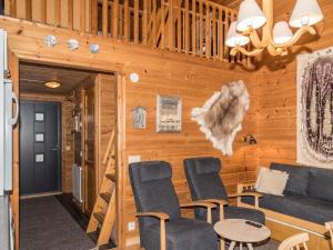 - un salon dans une cabane en rondins avec un canapé et des chaises dans l'établissement Holiday Home Lähikaltio 316 by Interhome, à Äkäslompolo 9 autres photos