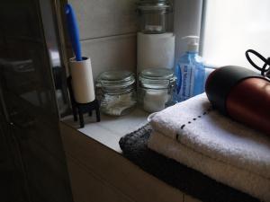 a bathroom counter with a shelf with towels and a window at Kamienica Bydgoska 2 in Bydgoszcz