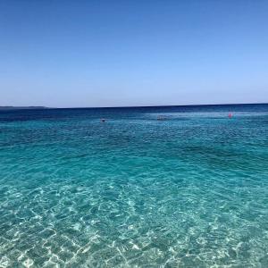 un grande corpo di acqua blu con persone nell'oceano di Villa Ermali a Ksamil