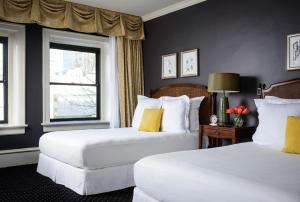 two white beds in a room with two windows at Hotel Sorrento in Seattle
