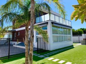 une maison avec un palmier en face dans l'établissement 9 Moderna Villa Independiente -Jacuzzi- Gran Alacant, à Puerto Marino