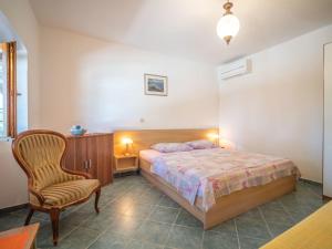 a bedroom with a bed and a chair at Apartment Villa Karolina by Interhome in Opric