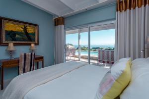 a bedroom with a bed and a large window at Benguela in Gansbaai