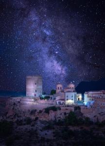 a starry night with the milky way over a city at Espuna Walks Casa Los Arcos in Totana