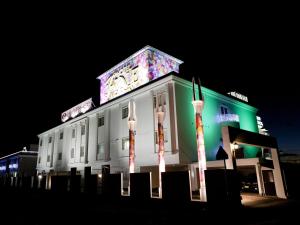 a white building with a lit up sign on it at Hotel Fine Garden Matsuzaka II in Matsuzaka