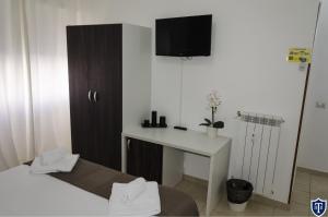 a room with a bed and a desk and a tv at TIBURTINA INN GUEST HOUSE in Rome