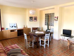 uma sala de estar com uma mesa e cadeiras e uma televisão em Casa Lanze em Castagnole Lanze