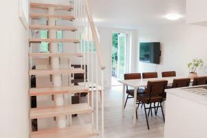 a white staircase in a living room with a table and chairs at Bergakungen Stugby in Osby