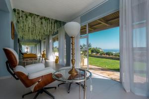 uma sala de estar com uma mesa de vidro e vista para o oceano em Benguela em Gansbaai