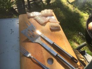 a wooden cutting board with a knife and fork on it at Houses by The Sea in Salpar +21 photos