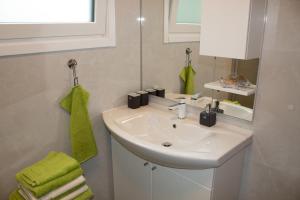 La salle de bains est pourvue d'un lavabo blanc et d'une serviette verte. dans l'établissement Ernas Ferienhaus, à Aschbach bei Fürstenfeld