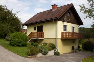 een geel huis met een bruin dak bij Ernas Ferienhaus in Aschbach bei Fürstenfeld
