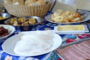 a table topped with plates of food and other foods at Pousada Residencial Porto de Galinhas in Porto De Galinhas