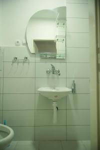 ein weißes Badezimmer mit einem Waschbecken und einem Spiegel in der Unterkunft Kuća za odmor ''S'' in Mladenovo